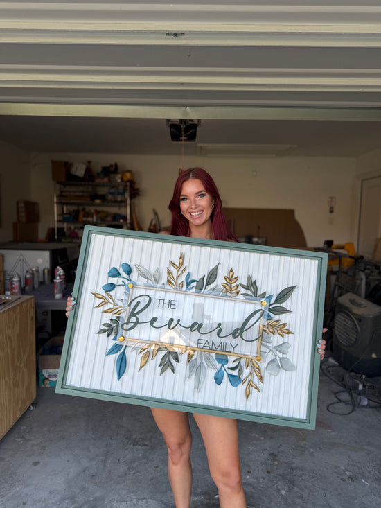 Bevard Family sign with white slats and colored green frame