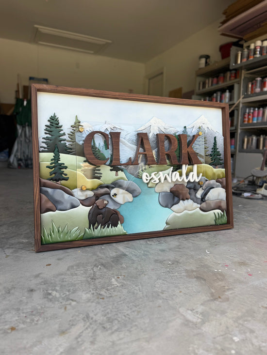 Clark Oswald wooden sign with mountains and creek