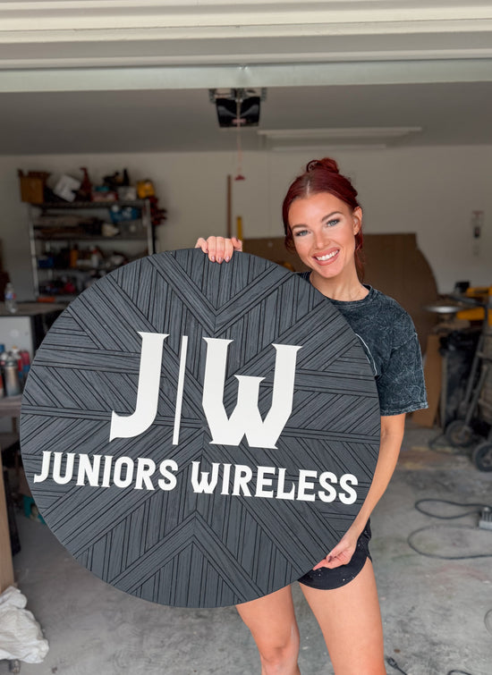 JW juniors wireless black mosaic round sign being held