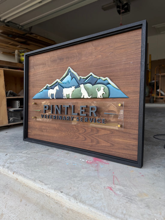 Pintler vet clinic logo with mountain and animal details wooden sign