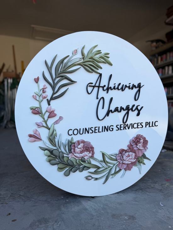 Achieving changes counseling services PLLC logo and flowers on a white wooden sign in a garage
