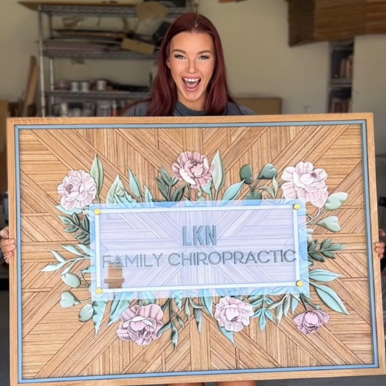 LKN family chiro logo sign with wooden background and pink flowers 