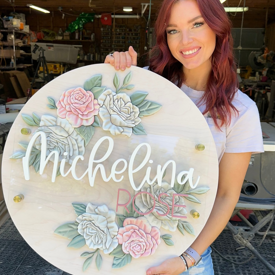 Michelina Rose sign on wooden round with two sets of rose flowers