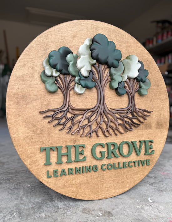 The Grover Learning Collective wooden sign with trees in garage